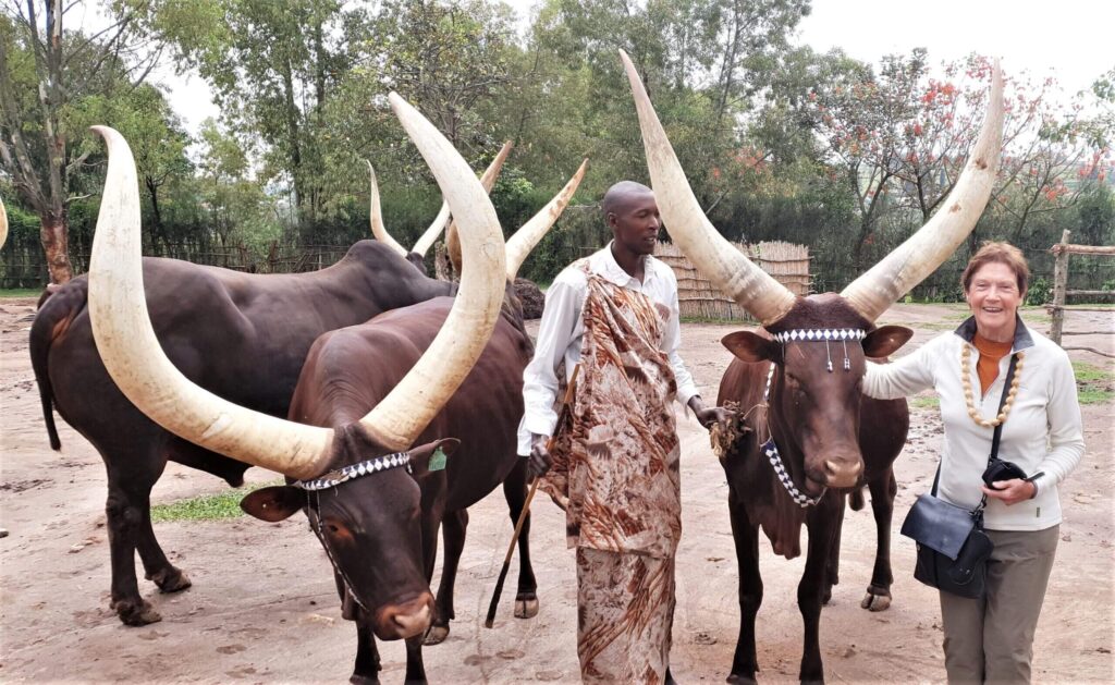 Happy travelers sitting down to enjoy a moment with the long horned cattle