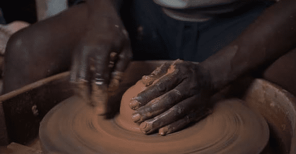 Traveler shaping clay during Craft Workshops in Burundi